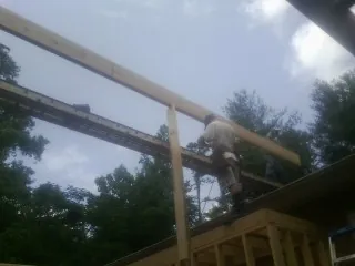 Carpenter setting a ridge beam over a new addition frame — Ice Dam Removal by Roofing Brothers in York Harbor