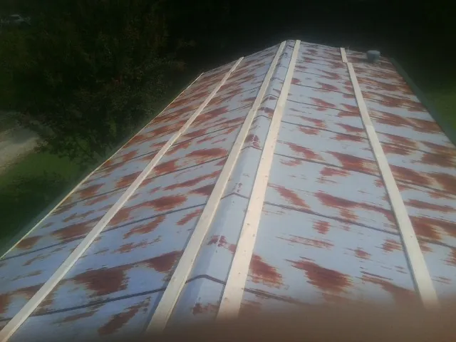Rusted metal roof panels with new wood purlins before replacement — Storm Damage Roof Repair in York Harbor by Roofing Brothers