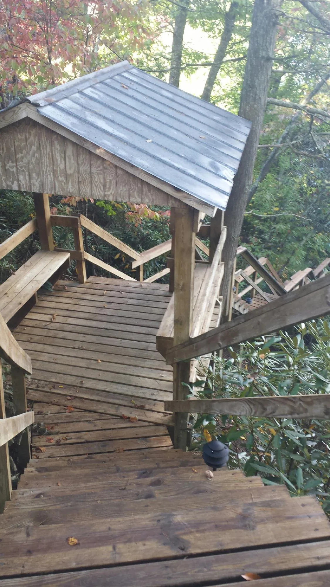 Metal roofed shelter over wooden steps on a wooded walkway — Skylight Repair & Installation work by our crew in York Harbor